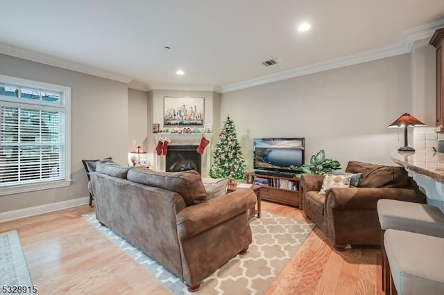 living room featuring crown molding and light wood-type flooring