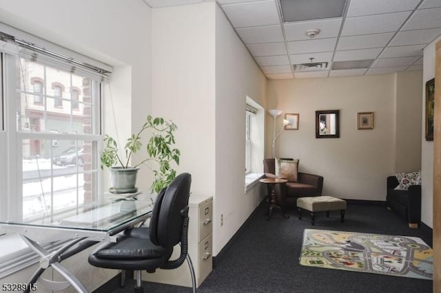 carpeted home office with a drop ceiling