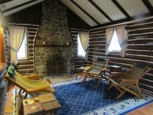 living area with hardwood / wood-style flooring, plenty of natural light, a fireplace, and high vaulted ceiling