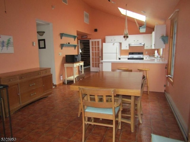 tiled dining space with high vaulted ceiling