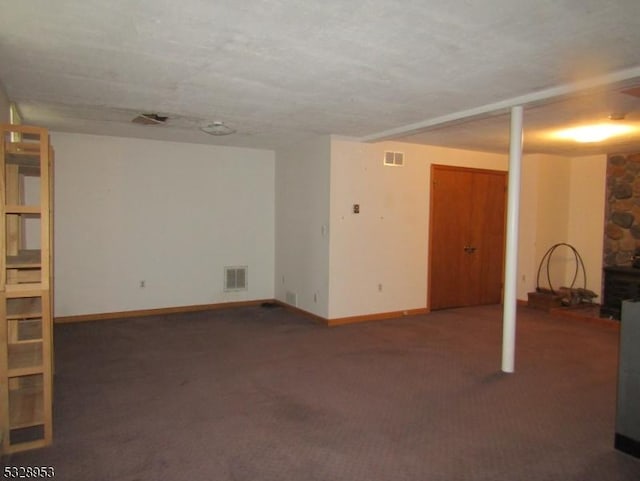 basement featuring dark carpet and a textured ceiling