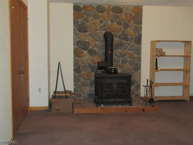 unfurnished living room with a wood stove and carpet