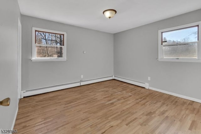 spare room with a wealth of natural light and light hardwood / wood-style flooring