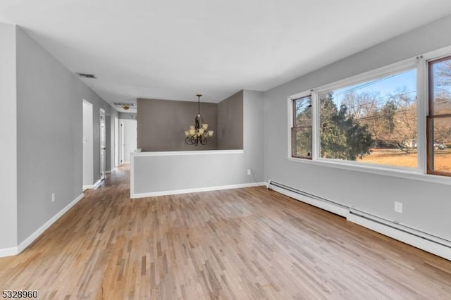 unfurnished room with a baseboard radiator, light wood-type flooring, and a notable chandelier