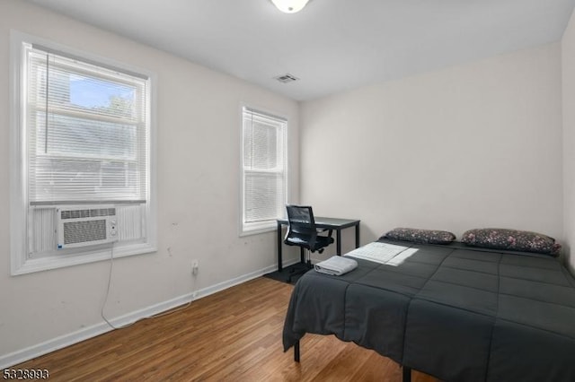 bedroom with wood-type flooring and cooling unit