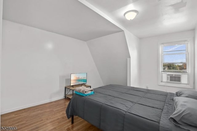 bedroom with wood-type flooring and lofted ceiling