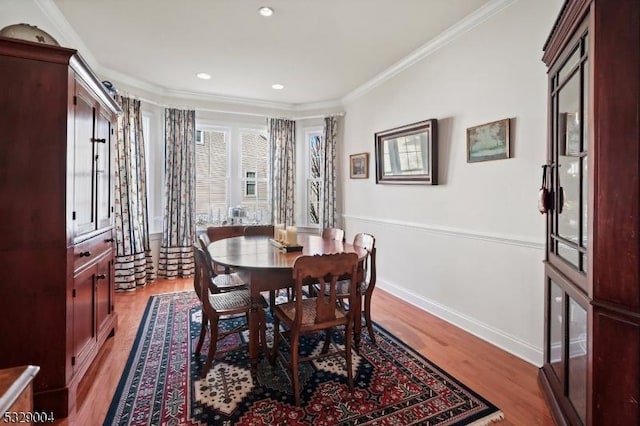 dining space featuring light hardwood / wood-style floors and ornamental molding