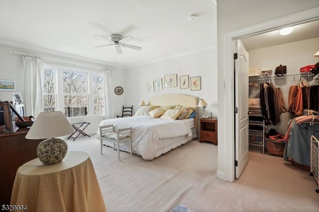 carpeted bedroom featuring ceiling fan, ornamental molding, and a closet