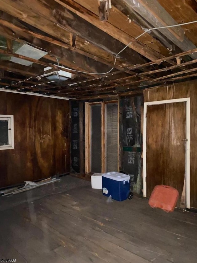 basement with wood walls and hardwood / wood-style floors