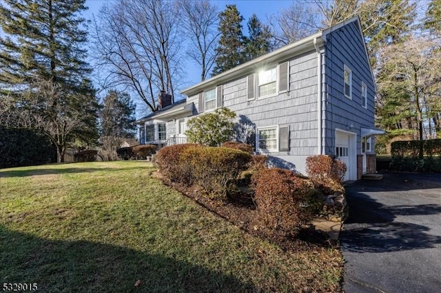 view of side of home with a yard and a garage