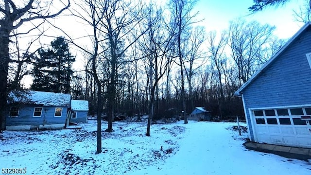 yard layered in snow featuring a garage