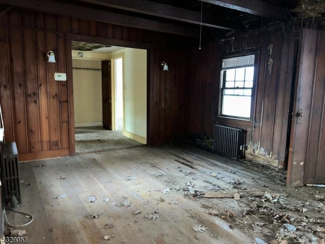 misc room featuring wood walls and radiator heating unit