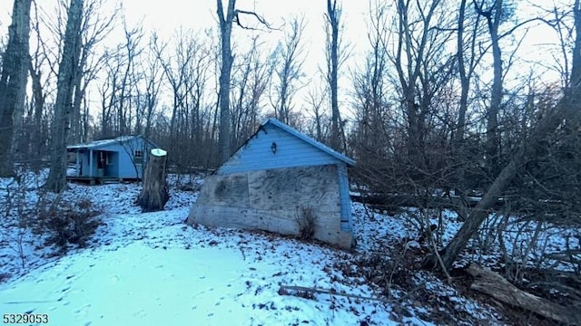 view of snow covered exterior with an outbuilding