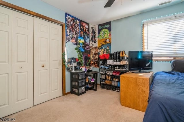 carpeted bedroom featuring a closet and ceiling fan