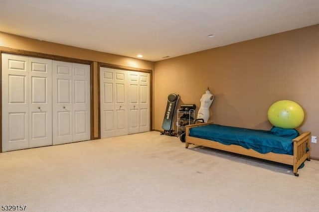 bedroom featuring carpet flooring and two closets