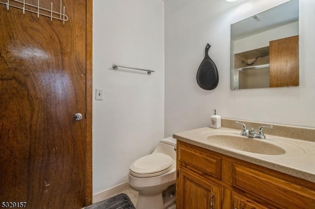 bathroom with vanity, toilet, and a shower with shower door