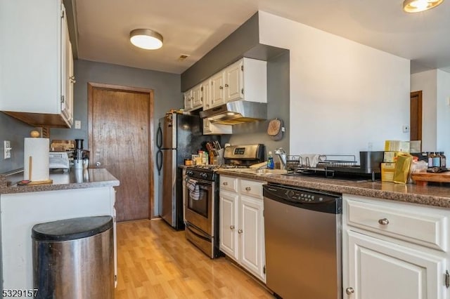 kitchen with white cabinets, stainless steel appliances, and light hardwood / wood-style floors