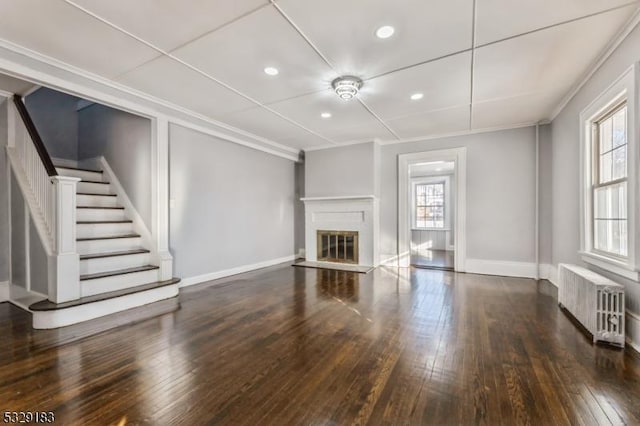 unfurnished living room featuring radiator, crown molding, and dark hardwood / wood-style floors