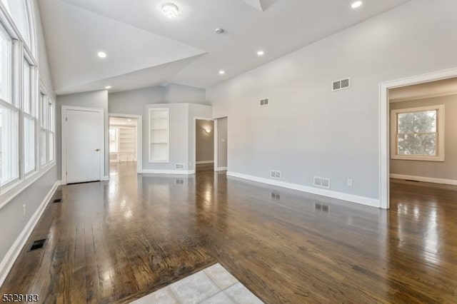 unfurnished living room with built in shelves, high vaulted ceiling, and dark wood-type flooring