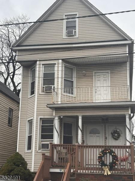 view of front of property featuring a balcony and a porch