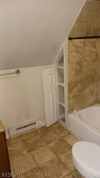 bathroom featuring shower / bathtub combination, baseboard heating, toilet, and vaulted ceiling