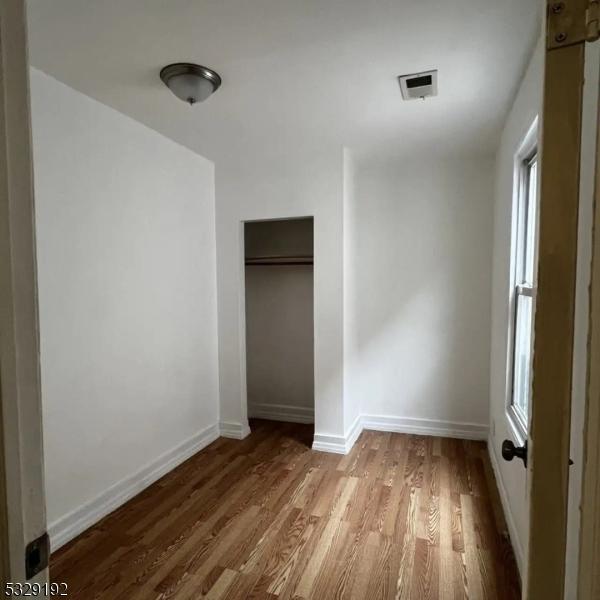 unfurnished bedroom with wood-type flooring and a closet