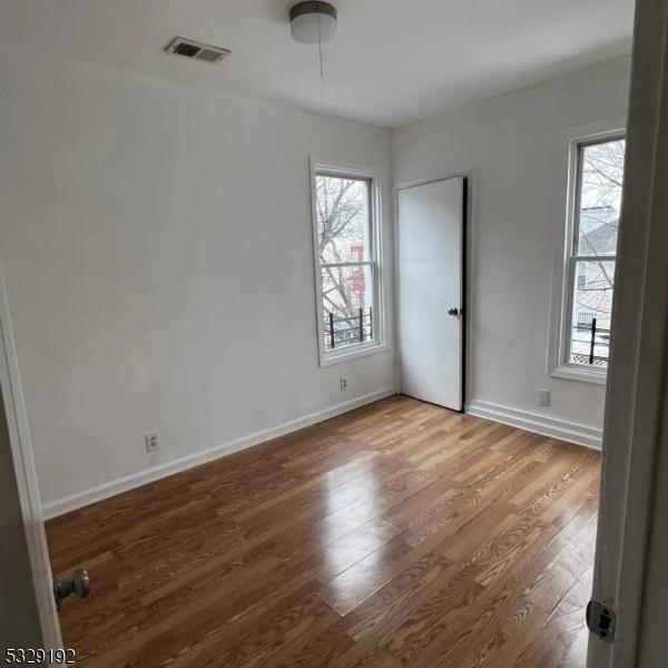 spare room with hardwood / wood-style floors and a healthy amount of sunlight