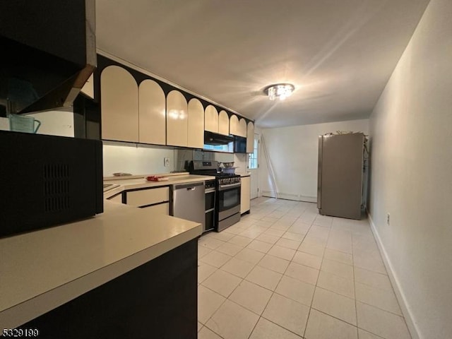 kitchen featuring light tile patterned floors, appliances with stainless steel finishes, light countertops, baseboards, and under cabinet range hood