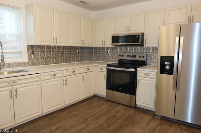 kitchen featuring backsplash, dark hardwood / wood-style flooring, sink, and stainless steel appliances