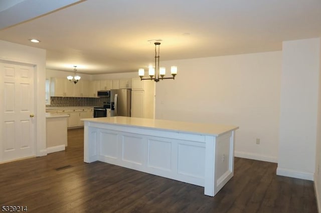 kitchen with a chandelier, white cabinets, stainless steel appliances, and decorative light fixtures