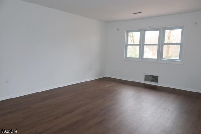 spare room featuring dark wood-type flooring