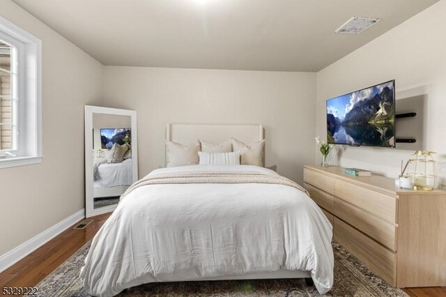 bedroom with dark hardwood / wood-style flooring