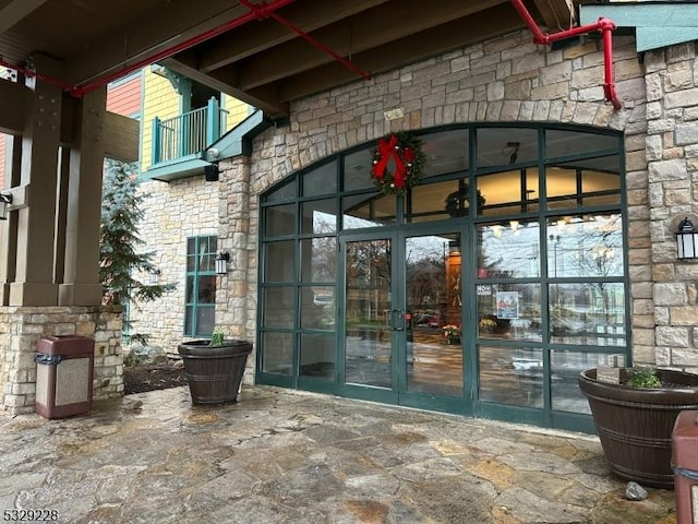 property entrance featuring a balcony and french doors