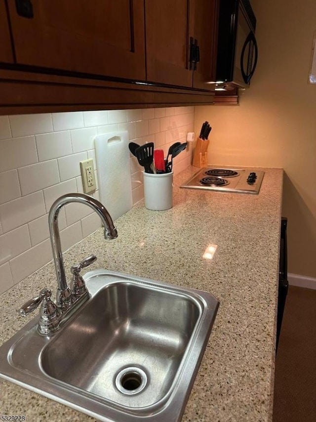 200 State Rt 94 Unit 338, Vernon Twp, NJ 07462 - kitchen view of black microwave, decorative backsplash, stainless steel electric cooktop, and light stone countertops