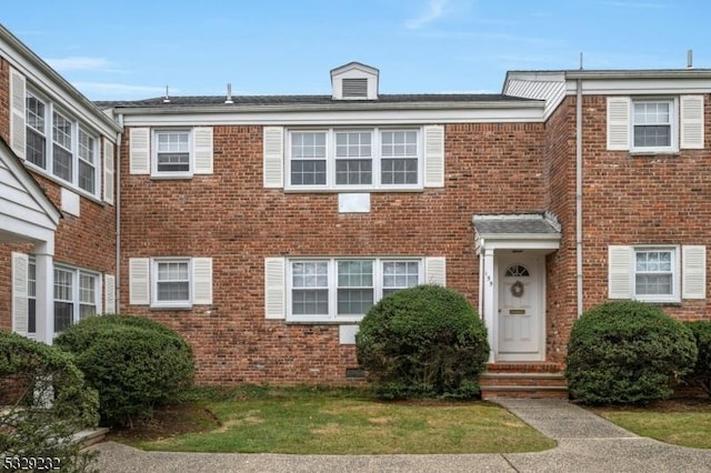 townhome / multi-family property featuring a front lawn