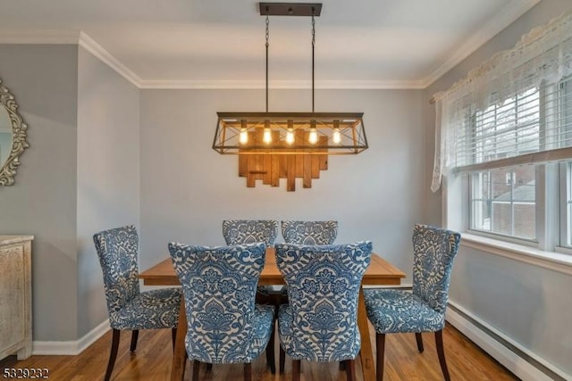 dining area featuring wood-type flooring, crown molding, a wealth of natural light, and a baseboard heating unit