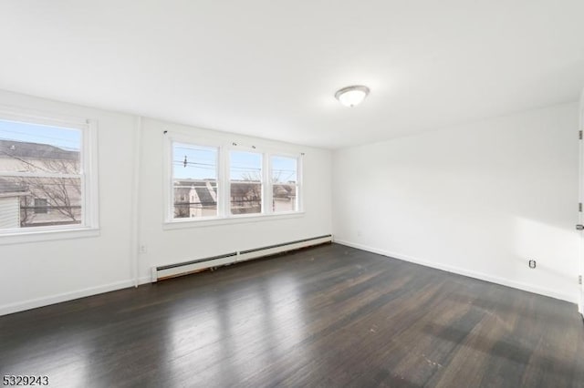 spare room with baseboard heating and dark wood-type flooring