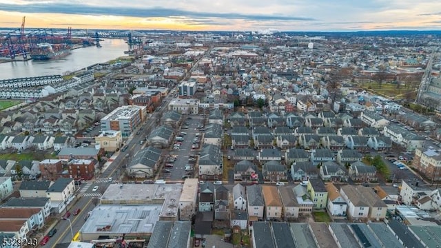 aerial view at dusk featuring a water view