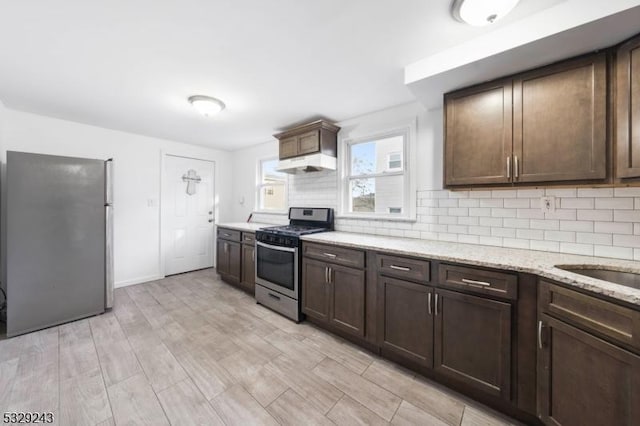 kitchen with tasteful backsplash, dark brown cabinetry, and stainless steel appliances