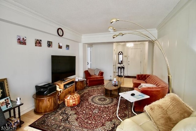 living room with a textured ceiling, ornamental molding, and hardwood / wood-style flooring