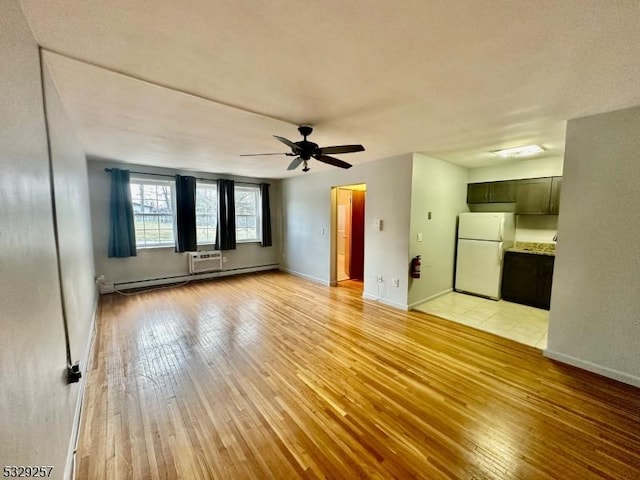 unfurnished living room featuring an AC wall unit, ceiling fan, baseboard heating, and light wood-type flooring