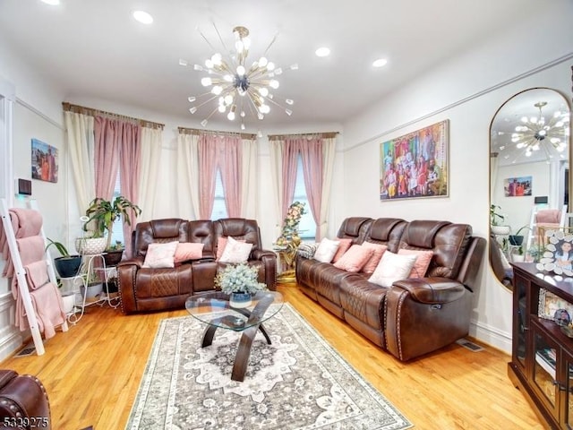 living room featuring light wood-type flooring and a notable chandelier