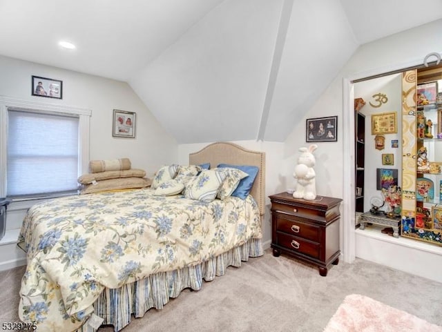 bedroom featuring light colored carpet and lofted ceiling