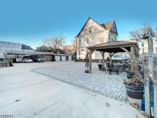 view of patio / terrace with a gazebo and an outbuilding