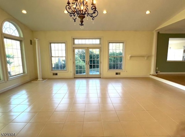 empty room featuring french doors, a healthy amount of sunlight, and light tile patterned flooring