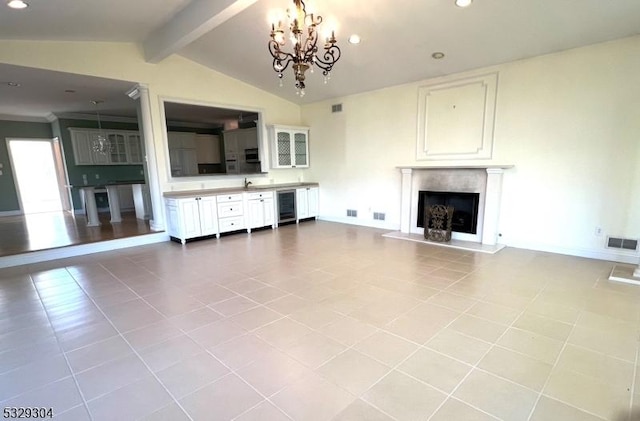 unfurnished living room featuring beverage cooler, light tile patterned floors, lofted ceiling with beams, and an inviting chandelier