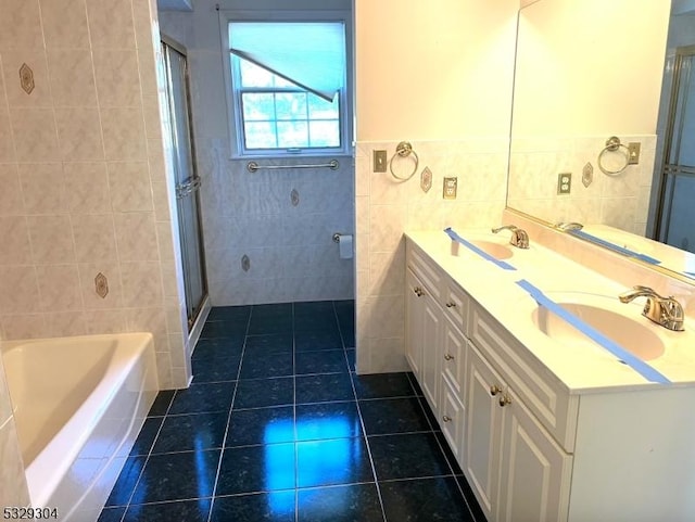 bathroom featuring tile patterned flooring, vanity, tile walls, and independent shower and bath