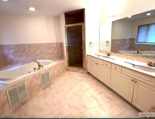 bathroom with tile patterned floors, vanity, and shower with separate bathtub