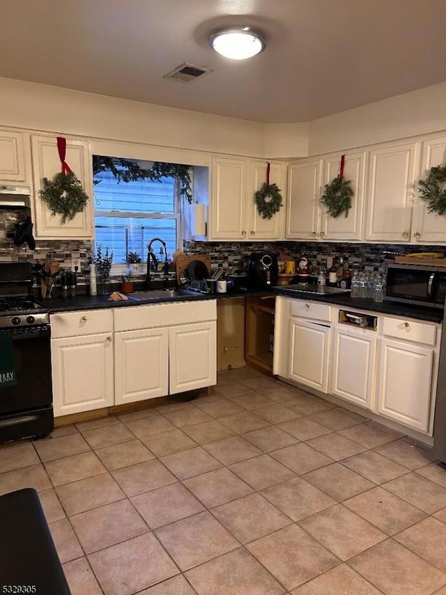 kitchen with light tile patterned floors, backsplash, black range with electric stovetop, and sink