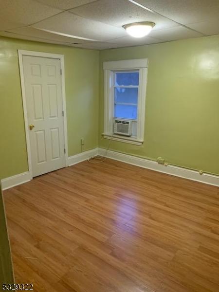 unfurnished room featuring cooling unit and light wood-type flooring